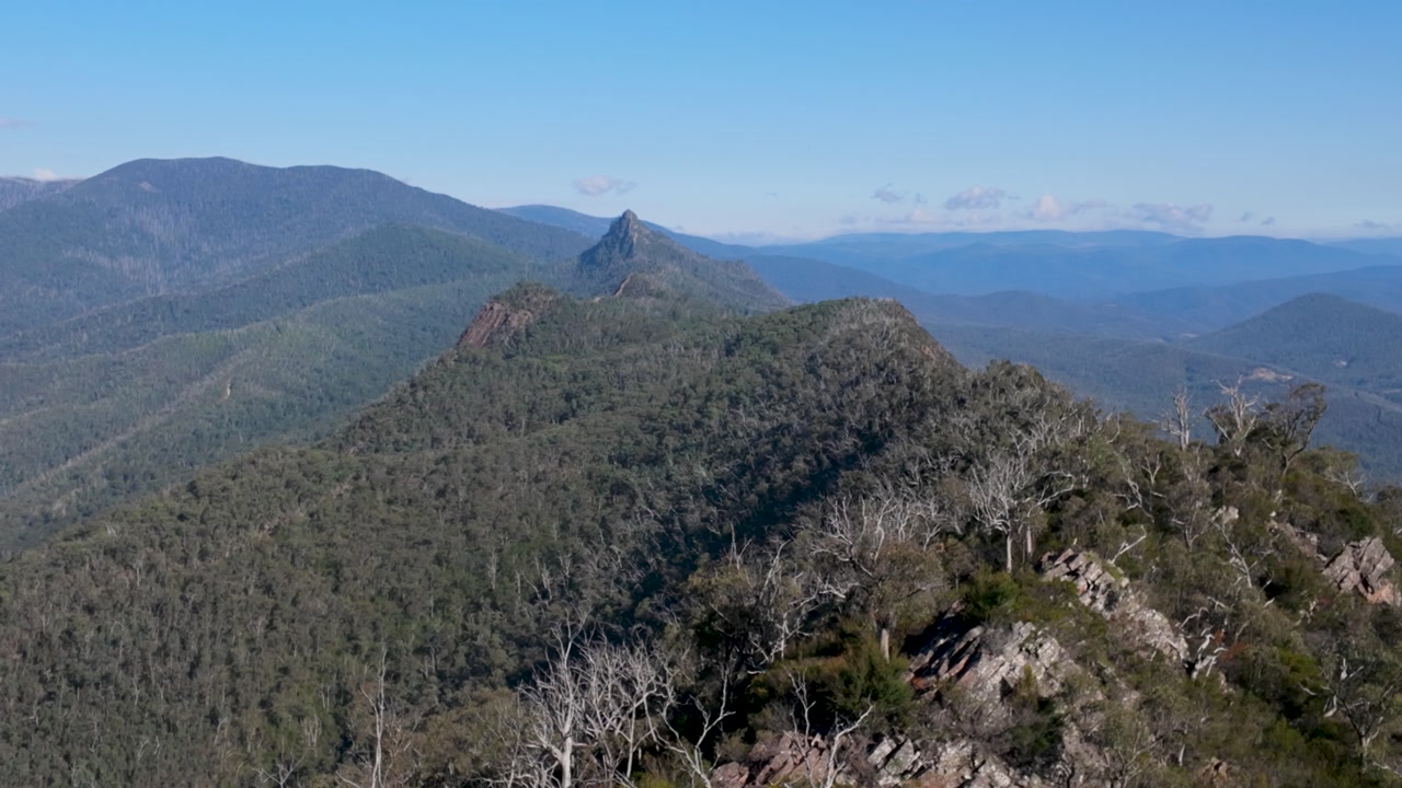 Long shot captures Sugarloaf Peak from Razorback Ridgeline, revealing rugged mountains, layered valleys, and sweeping alpine scenery under soft natural light.