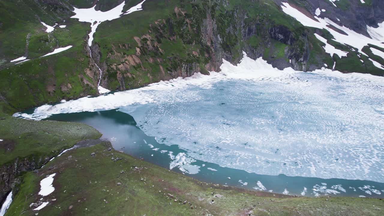 부분적으로 얼어붙은 라티 갈리 호수와 눈어리, 푸른 초원
