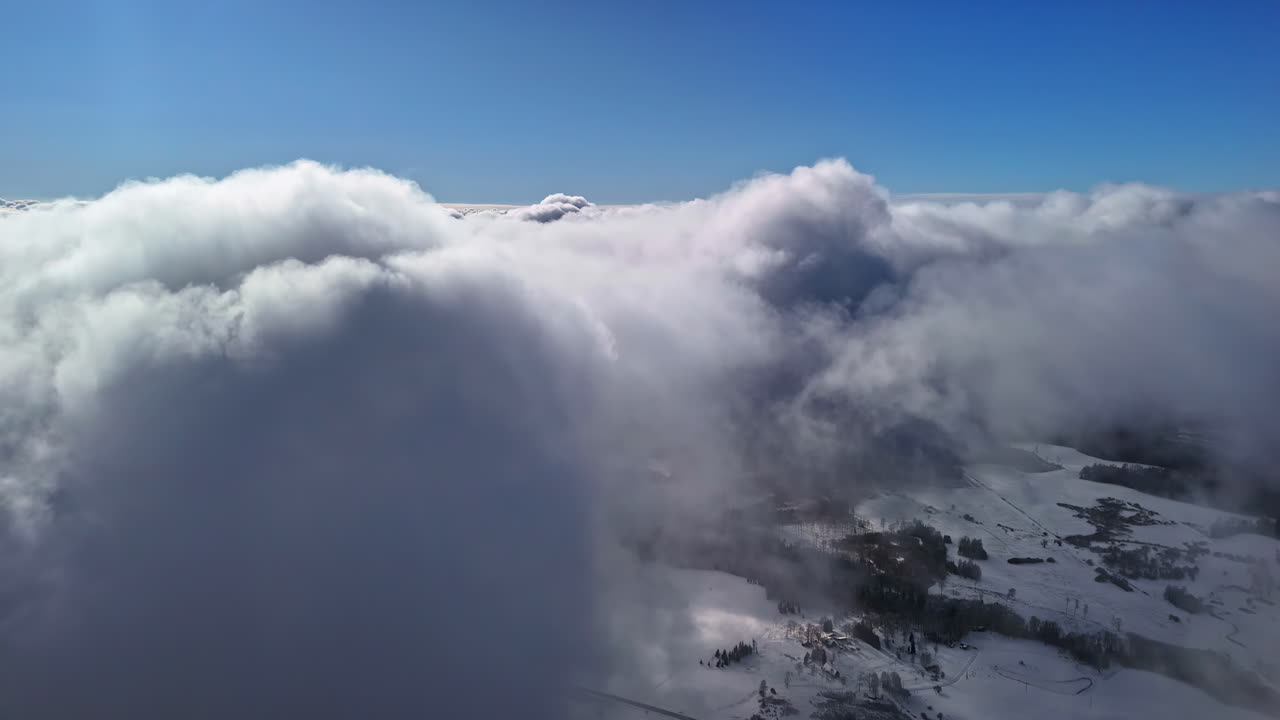 A white cloud cover under a blue sky above a winter landscape