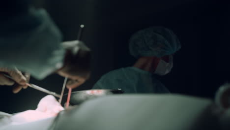 closeup surgical hands using medical instruments for operation in hospital ward.