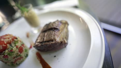 un hermoso plato de filete de lomo acompañado de una ensalada de quinua, una deliciosa y saludable combinación de sabores y texturas
