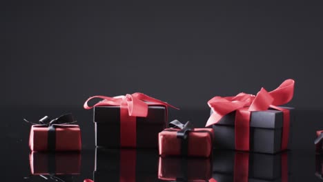 video of gift boxes with red and black ribbons and copy space over black background