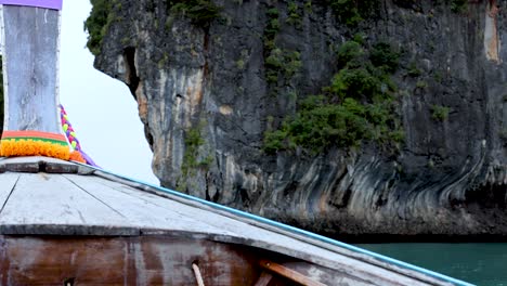 un barco se acerca a impresionantes acantilados en tailandia