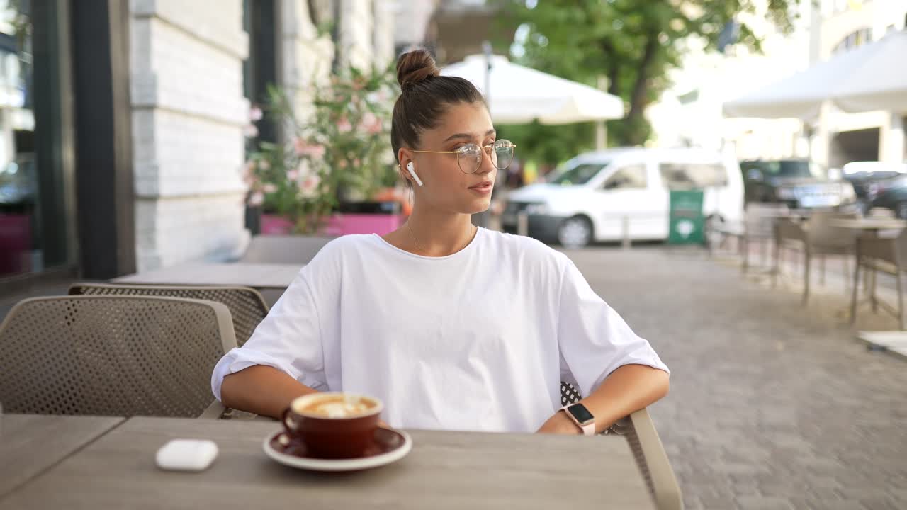 una mujer joven disfrutando de café en un café al aire libre