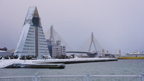 Aomori-Tourism-Building-and-Bridge-at-Waterfront,-Covered-in-Snow,-Japan-Winter