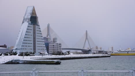 edificio de turismo aomori y puente frente al mar, cubierto de nieve, invierno de japón