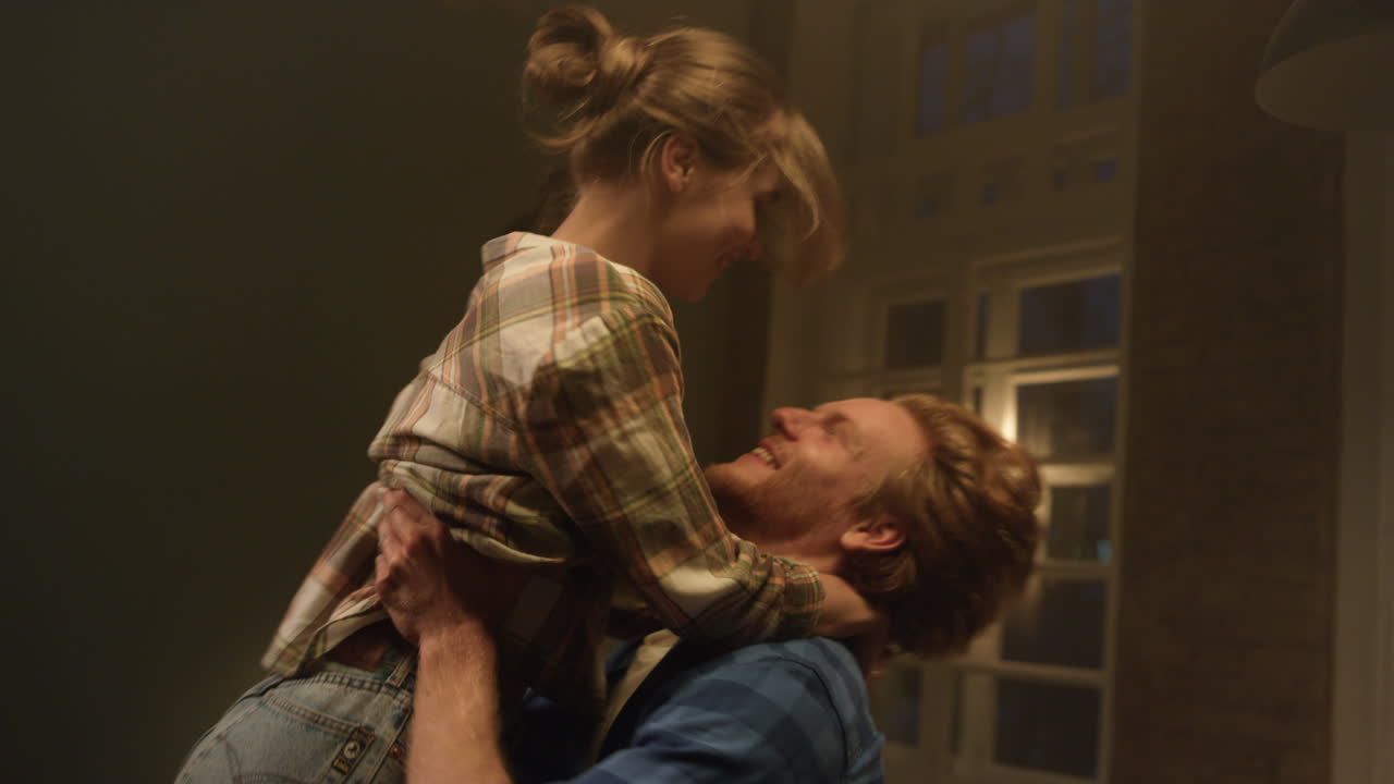 Happy couple enjoying renovated house. Man hugging woman in new apartment.