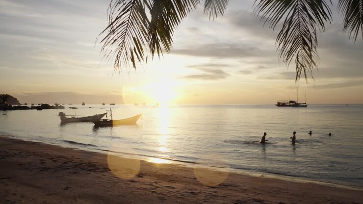 Tropical Sunset Beach with Boats and Swimmers