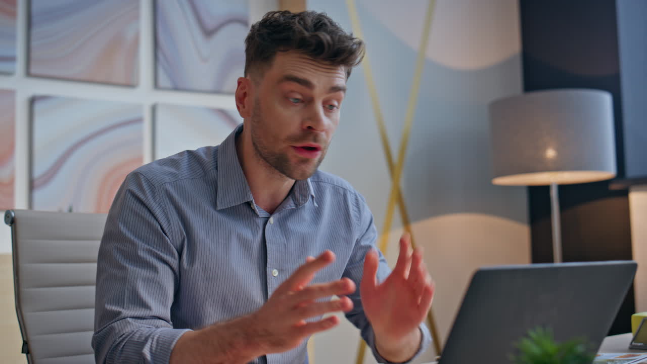 Uomo d'affari emotivo che litiga in videochiamata in un ufficio di agenzia, inquadratura ravvicinata. Uomo furioso.