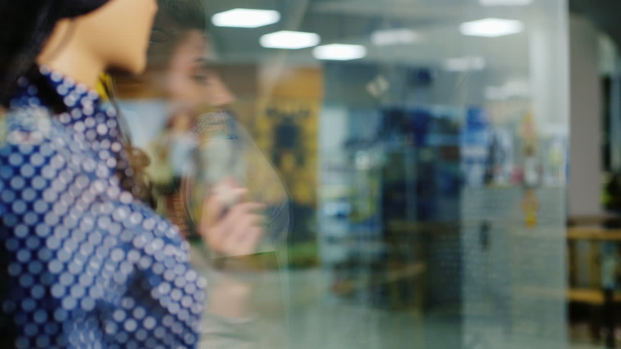Mulher atraente pronta para compras, examinando a vitrine da loja e segurando um cartão para compras