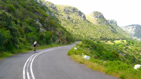 female cyclist cycling on a countryside road 4k