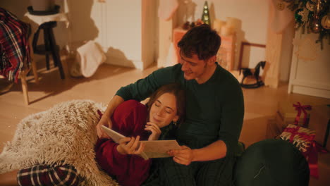 woman watching photo album with male friend