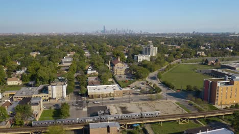 cinematic aerial view of subway train on chicago's south side in summer