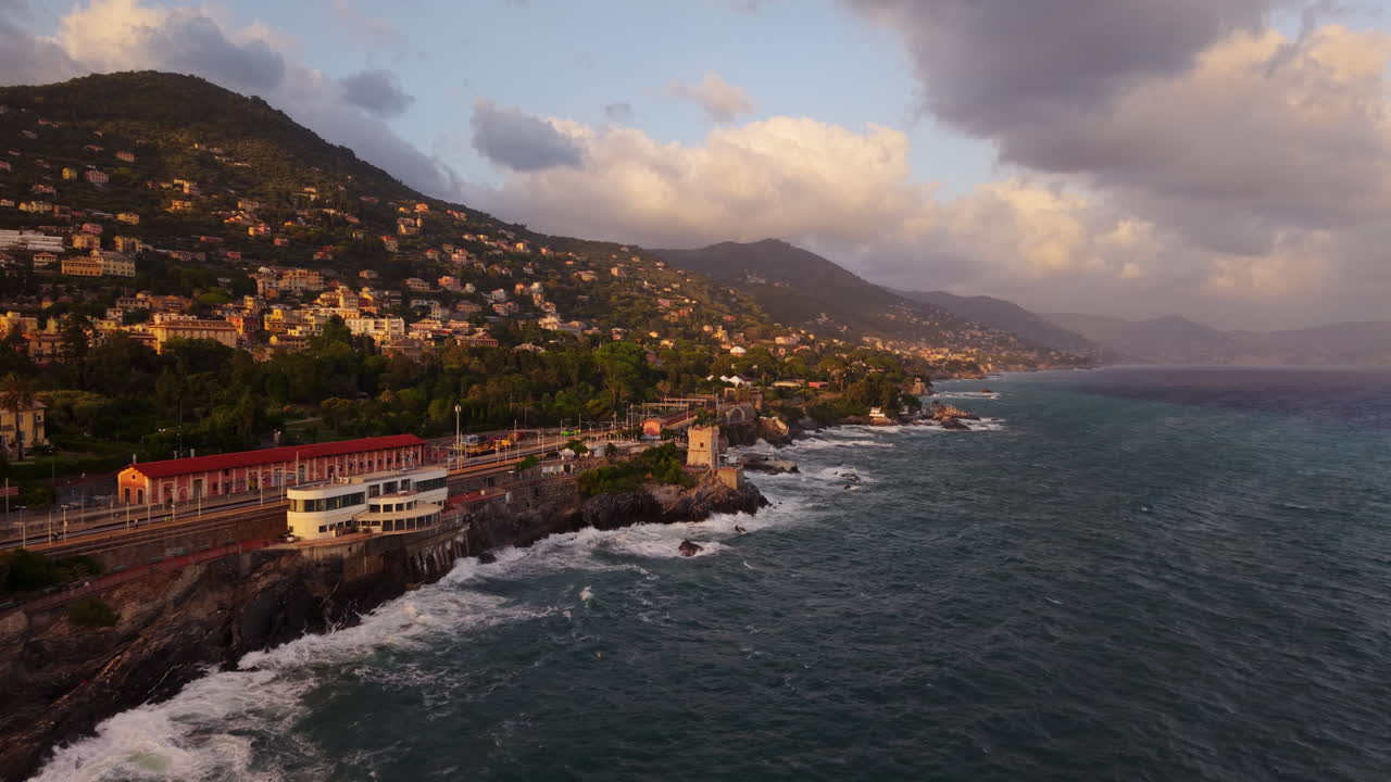 Mediterranean coast during sunset, beautiful aerial view, waves hit rocky shore, golden light falls on houses, peaceful nature and village scenes