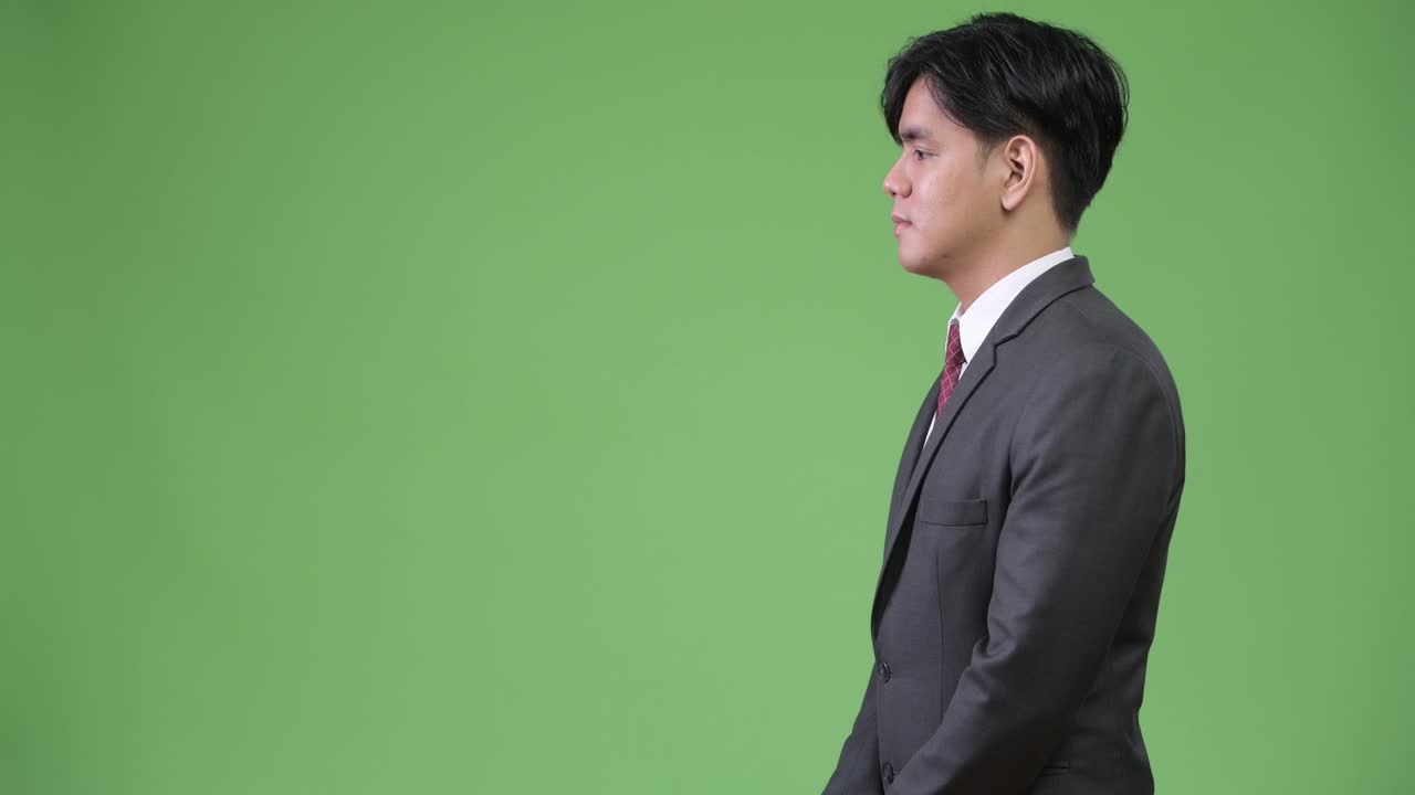 녹색 배경에 젊은 잘생긴 아시아 사업가