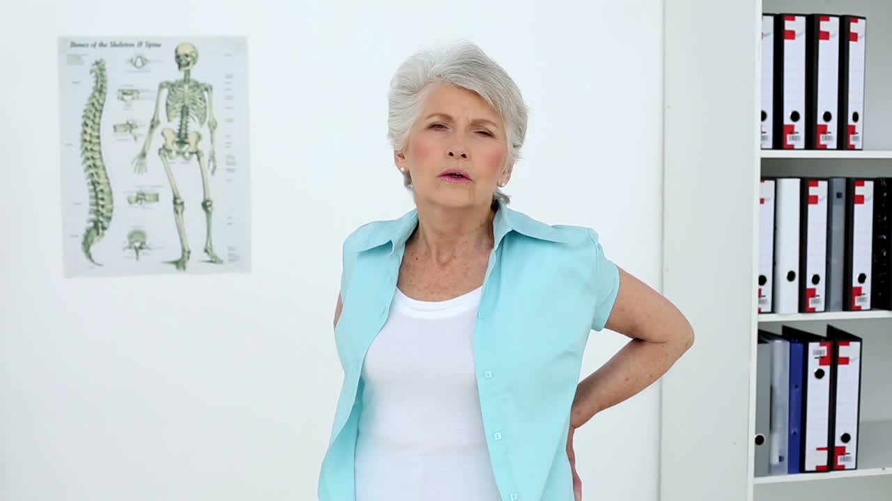 부상당한 환자가 그녀의 등을 만지고 있습니다.