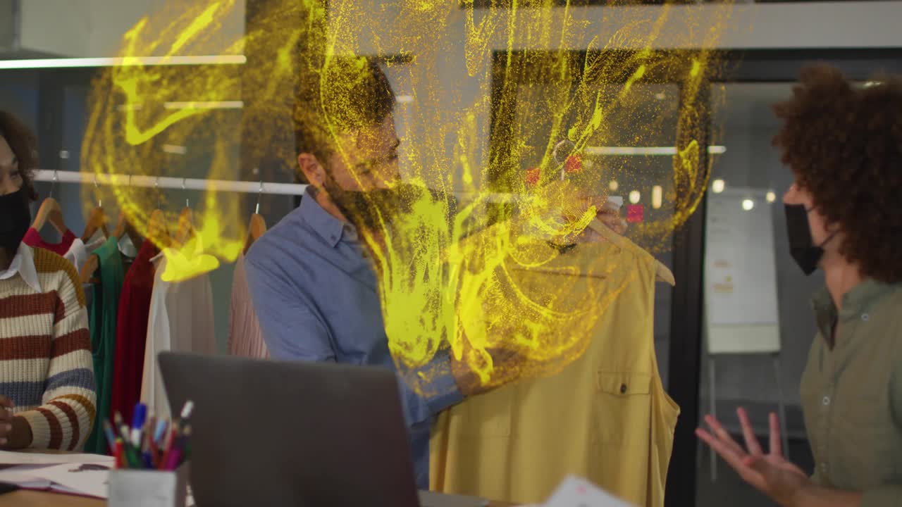 Presenter lifting hanger at design table, yellow swirl growing and accenting garment for review
