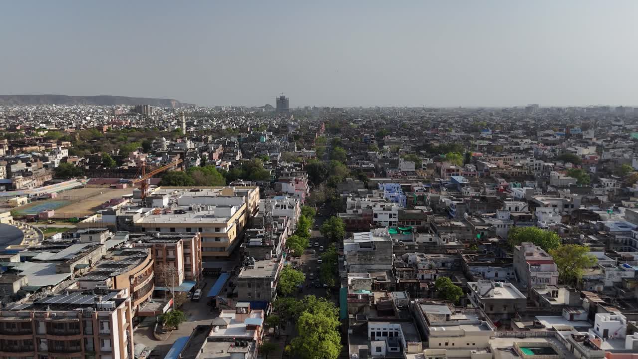 Overhead perspective of a historic fort wall cutting through Jaipur's hills.