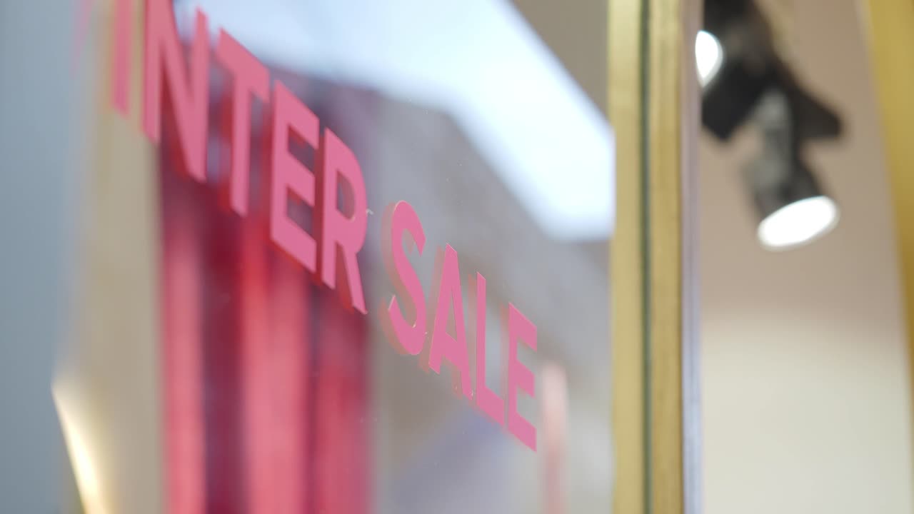 Pink 'Winter Sale' Sign Reflected on Shop Window