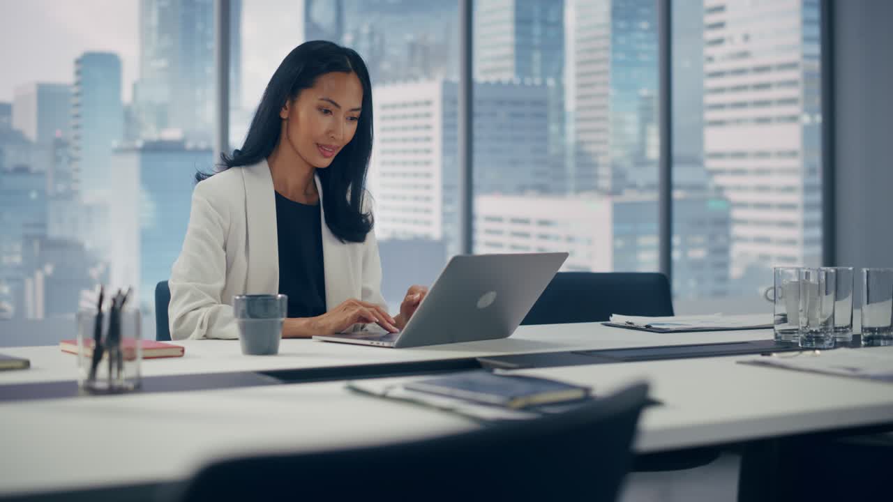 アジアの女性ビジネスマンの肖像画 - 大都市のオフィスでラップトップで働くスタイリッシュなスーツを着てデジタル電子商取引プロジェクトデータ分析製品マーケティングを管理する強力なceo