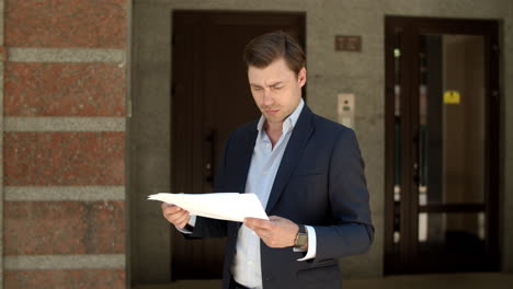 hombre de primer plano leyendo documentos. hombre de negocios mirando documentos en la calle