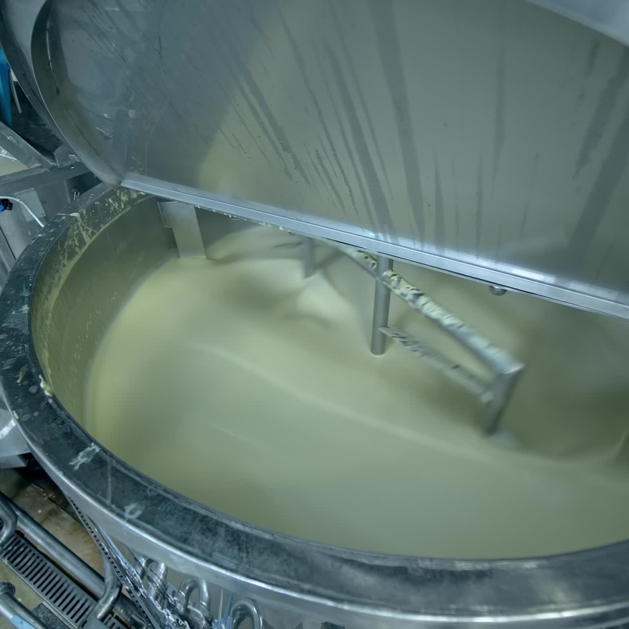 Industrial equipment for making butter. Modern container mixing butter at milk factory. Creamy dairy product in a tank