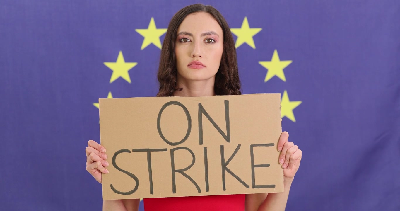 Donna attivista seria manifesta davanti alla bandiera dell'Unione Europea