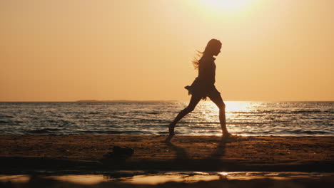 silhouette of a carefree child running along the beach
