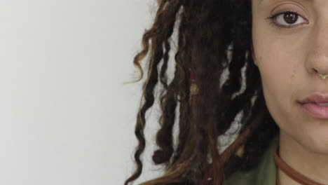 cerca hermosa joven mujer de raza mixta sonriendo mirando a la cámara mitad de la cara usando rastas peinado