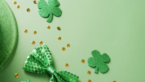 video of saint patricks day green shamrock, hat and bow tie with copy space on green background