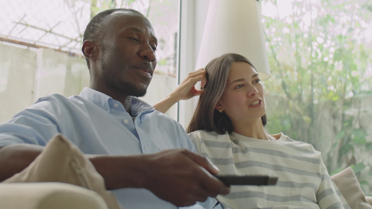 Multiethnic Family Couple Watching TV and Chatting at Home