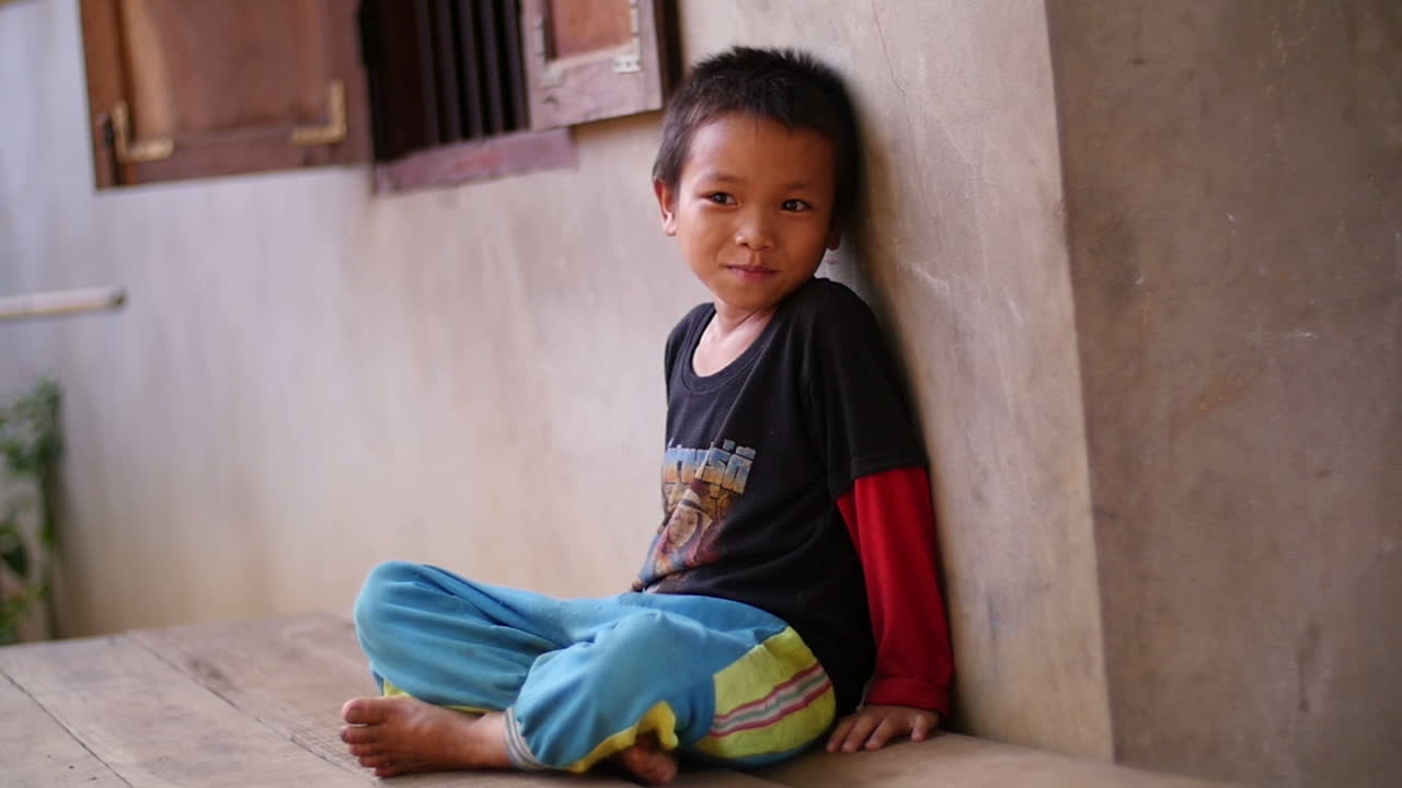 A Young Boy Sitting Outdoors