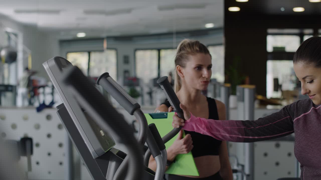 Coach training female athlete at gym