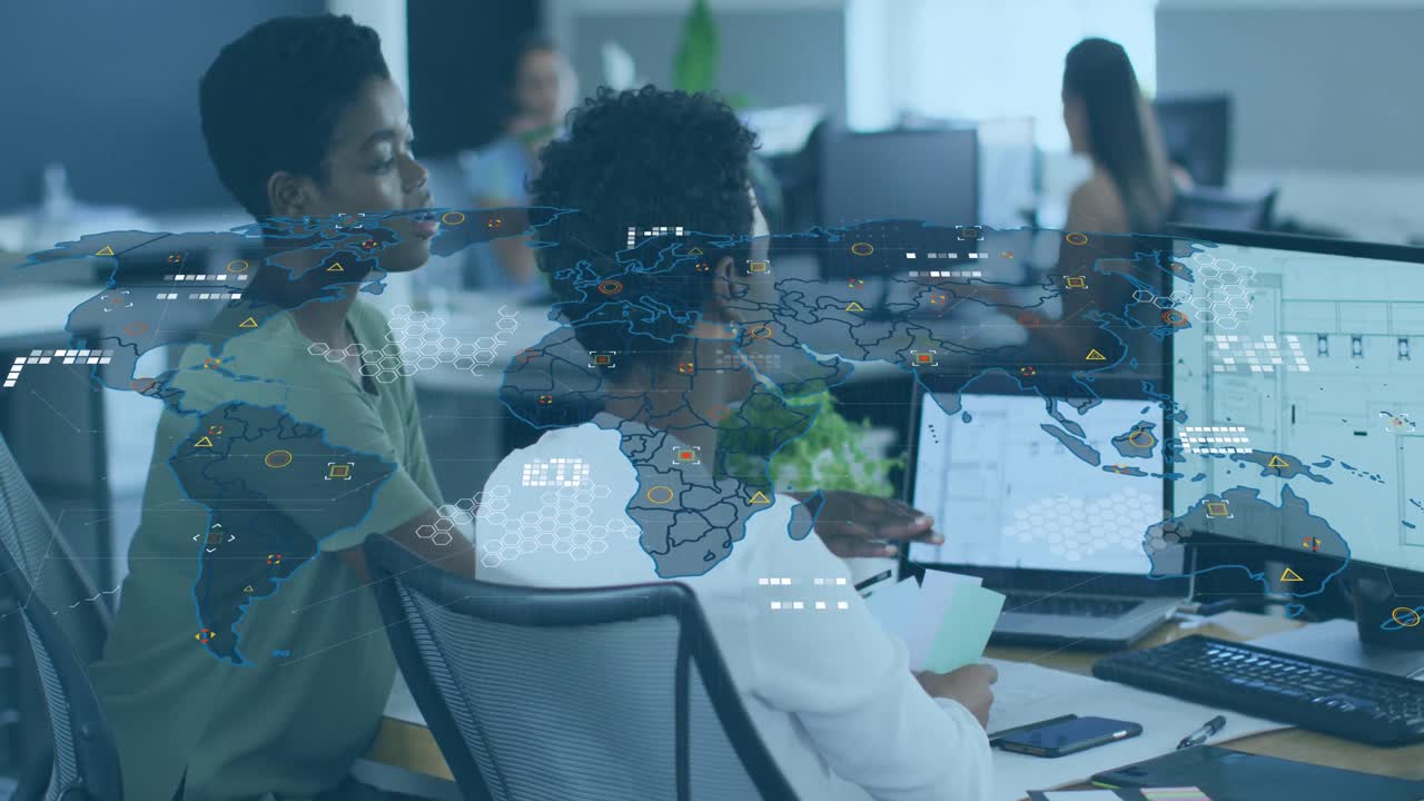 Animation of world map and icons over diverse female coworkers working in office