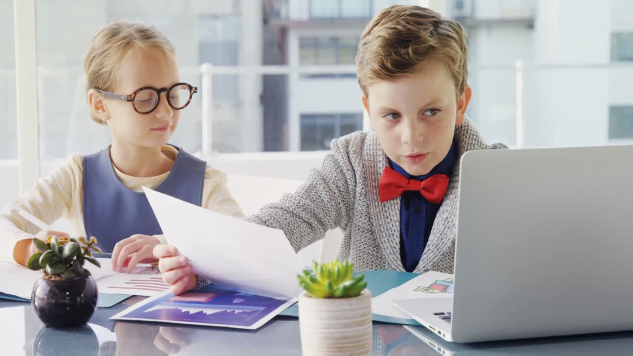 Børn som erhvervsledere, der diskuterer over en bærbar computer 4K