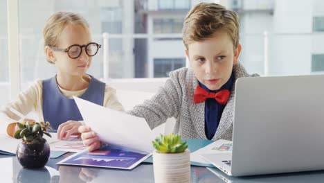 Kids-as-business-executives-discussing-over-laptop-4k