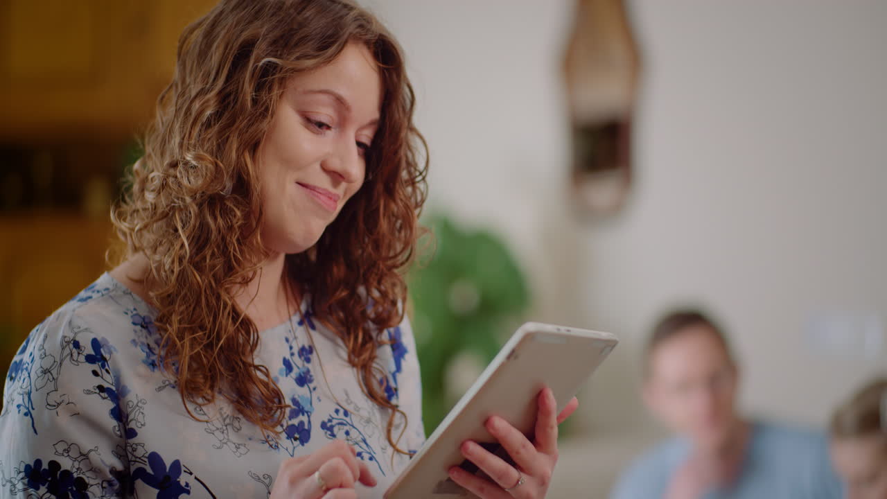 Happy Young Woman Smiling While Using a Digital Tablet