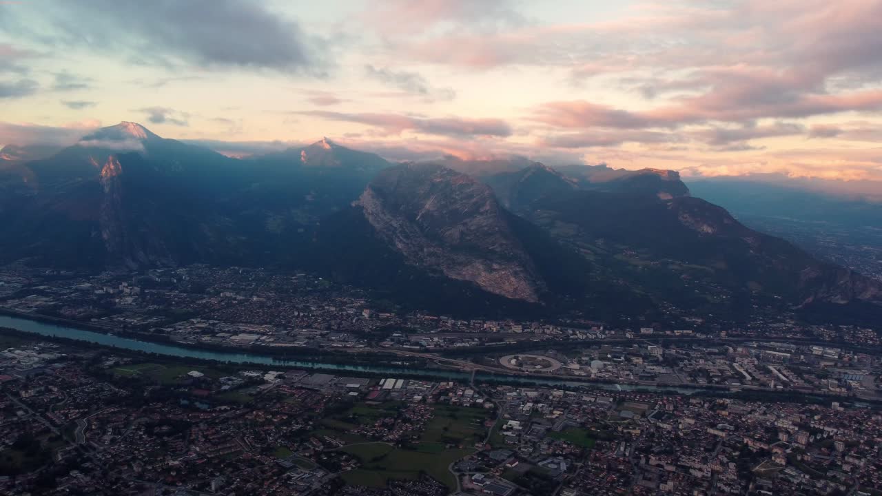 imágenes panorámicas aéreas de la ciudad de grenoble entre el río y la montaña de los altos alpes durante una increíble puesta de sol nublada