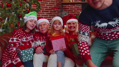 familia multigeneracional tomando una foto selfie en un teléfono móvil con temporizador en una casa decorada para navidad
