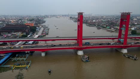 Foggy-day-over-Palembang-city-with-heavy-traffic-over-Ampera-bridge,-aerial-side-fly-view