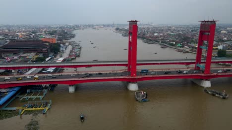 foggy day over palembang city with heavy traffic over ampera bridge, aerial side fly view