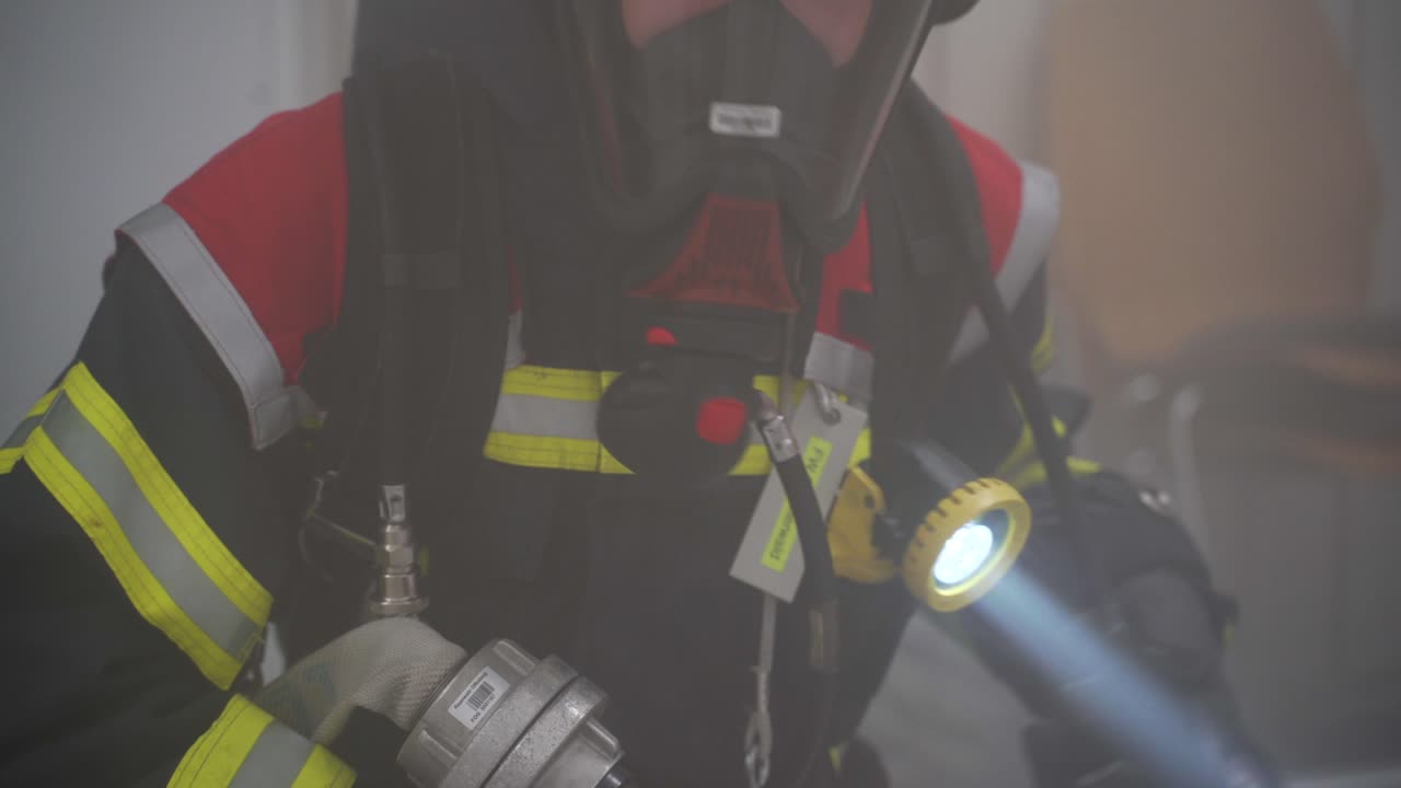 German firefighter with flashlight and respiratory protection
