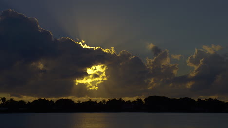 los rayos del sol salen de detrás de las nubes hacia el cielo en el sur de florida, u