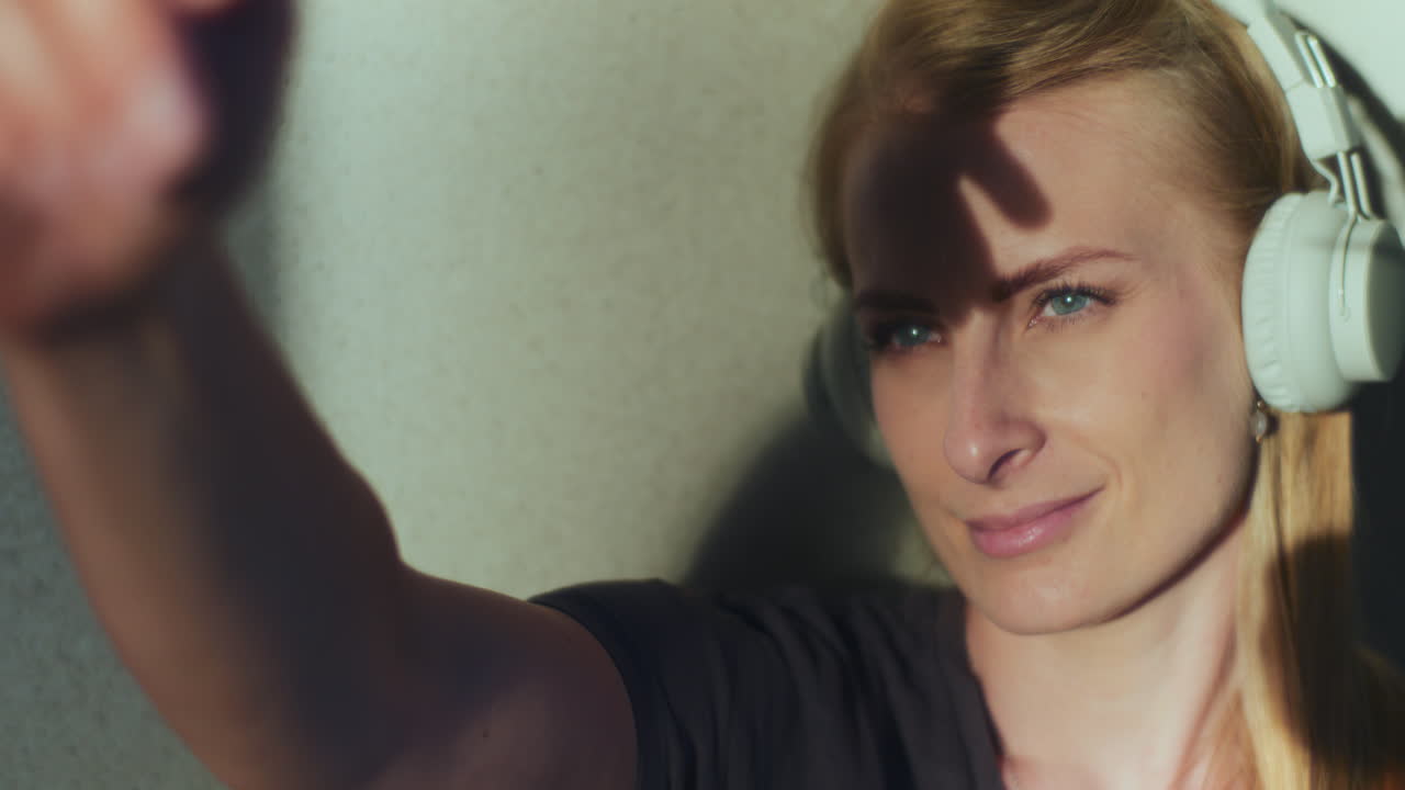 una mujer pensativa sueña y piensa, atrapando los rayos del sol que caen sobre ella con su mano