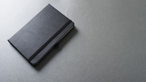 close up of closed gray notebook with copy space on gray background in slow motion