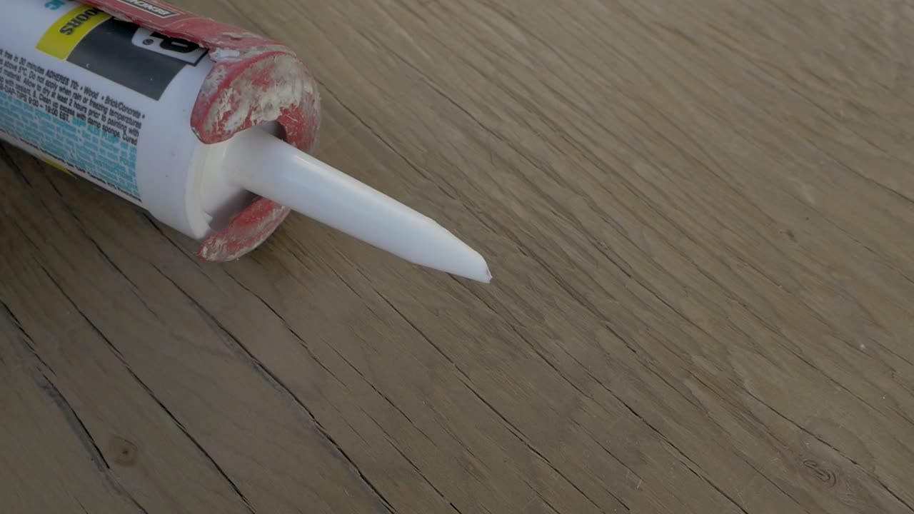 un carpintero ejecuta una perla de silicona a lo largo de una articulación