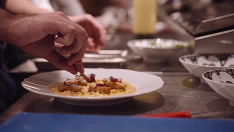 cocinero masculino prepara el plato de pasta para ser servido en un restaurante