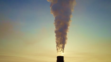 smoke from industrial chimney at sunrise/sunset