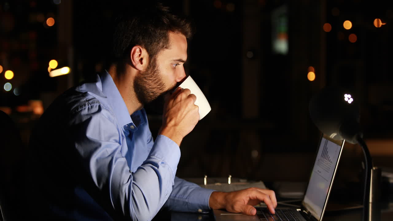 Businessman using laptop at night