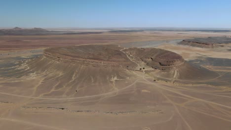 horseshoe rock formation also called spectre crater of remote travel destination gara medouar in morocco, aerial drone circling view